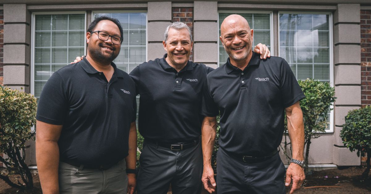 3 team members from Reach Dental Equipment smiling together.